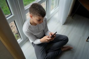 Как узнать, чем ребенок занимается в соцсетях? Подросток с телефоном