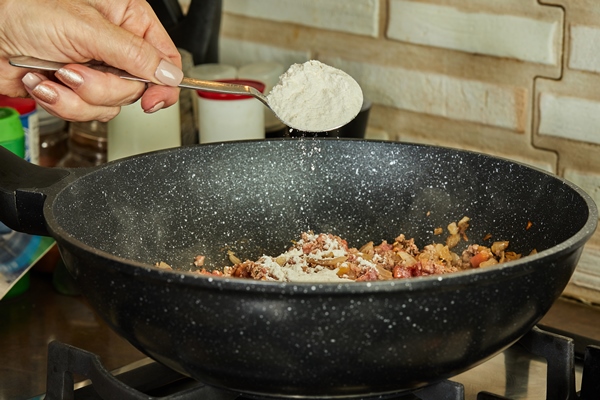 che chef pours chicken seasoning from spoon into frying pan - Овощи, бобовые, грибы: полезные советы