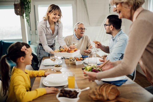 happy multigeneration family having lunch together at home men are talking among themselves while women are serving food at dining table - Советы по выбору рецептов