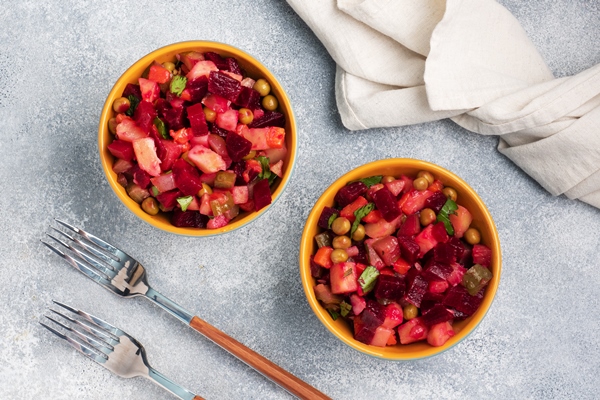 vinaigrette with beetroot and boiled vegetables traditional russian homemade salad serving bowls with a cold snack on the table copy space - Витаминный винегрет со снытью