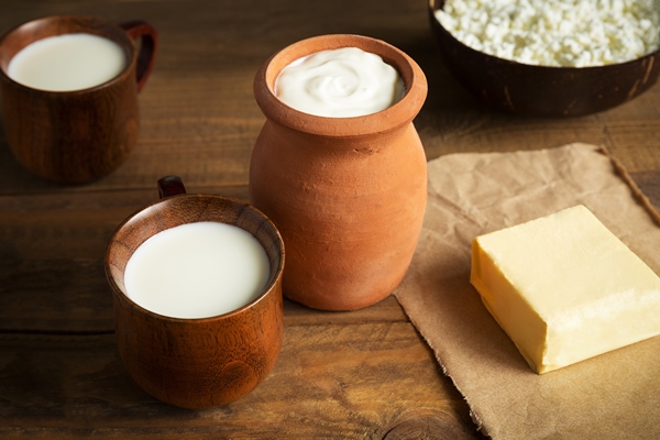 dairy products cottage cheese butter sour cream and milk close up on wooden brown background - Пасха обыкновенная