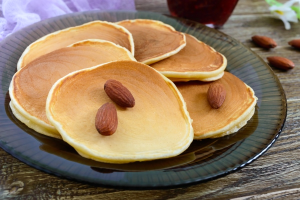 delicious almond pancakes with tea and jam on a wooden table close up - Постные блинцы из миндальной муки