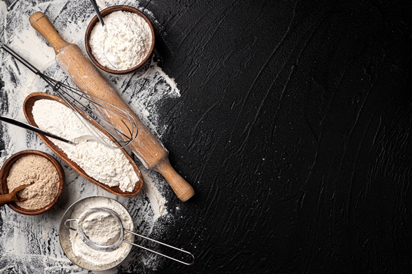 different types of flour in wooden bowls on black table top view - Постные гречневые блины на закваске