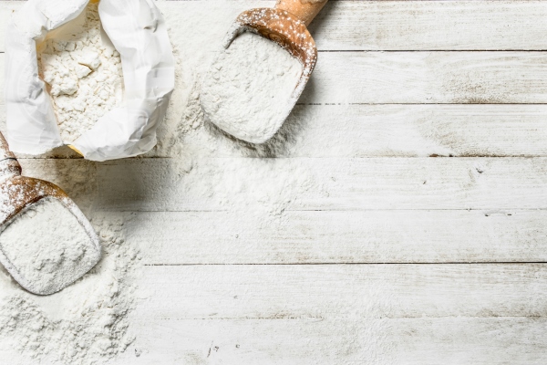 flour in bag with a shovel on a white wooden table - Кулич бабушкин