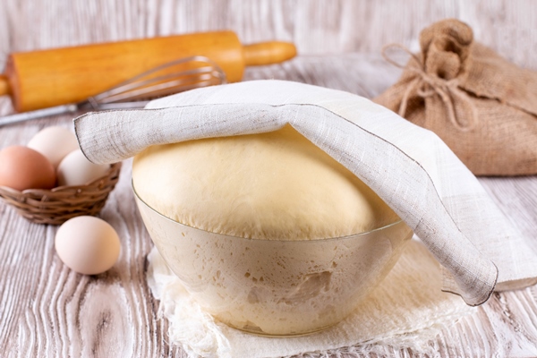 fresh yeast dough for pizza bread baguettes sourdough on wooden table yeast dough in a glass bowl - Кулич бабушкин