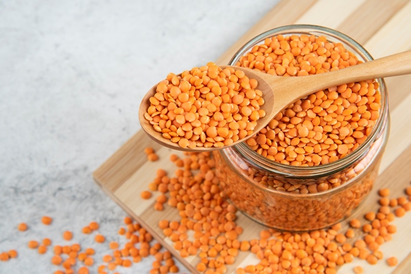 glass jar of red lentils with wooden spoon on wooden board 1 - Библия о пище