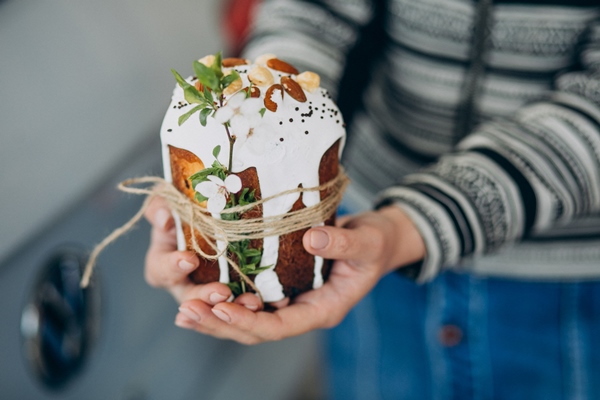 male hands holding easter paska - Кулич миндальный
