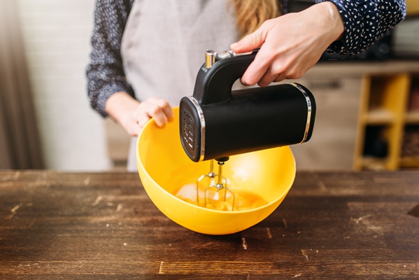 young woman in apron whip dough in bowl with - Испанское пасхальное печенье "Цветы"