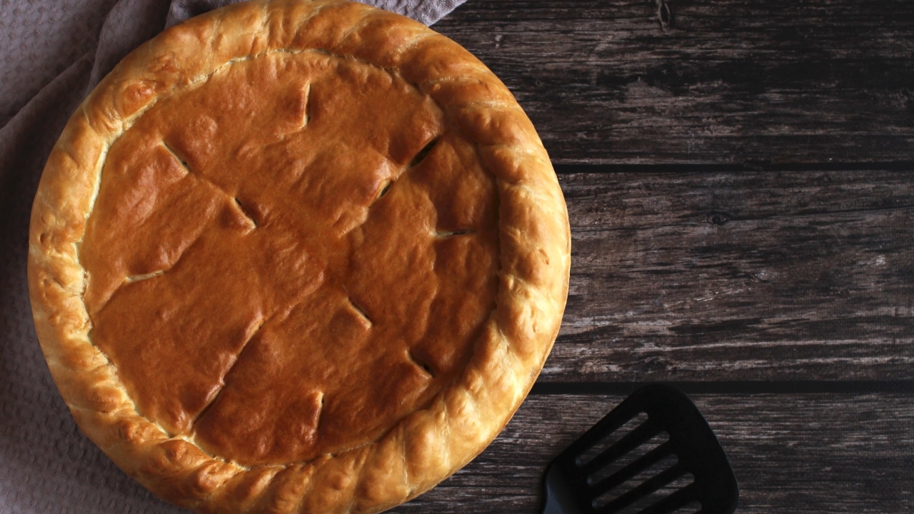 Пирог со свежей капустой и рыбой baked round cake with filling wooden background top view - Пирог со свежей капустой и рыбой