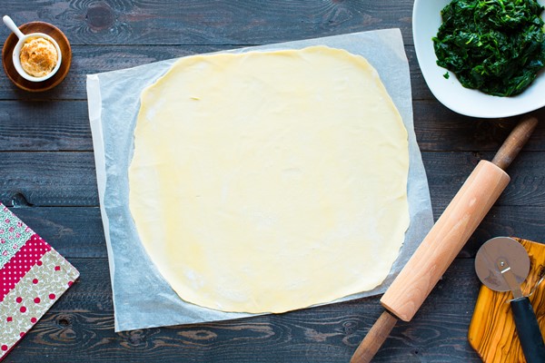 delicious pie with spinach made at home on a wooden background - Пирог со щавелем закрытый