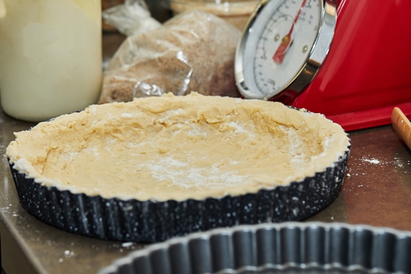 dough in cake tin according to the recipe - Пирог со щавелем закрытый