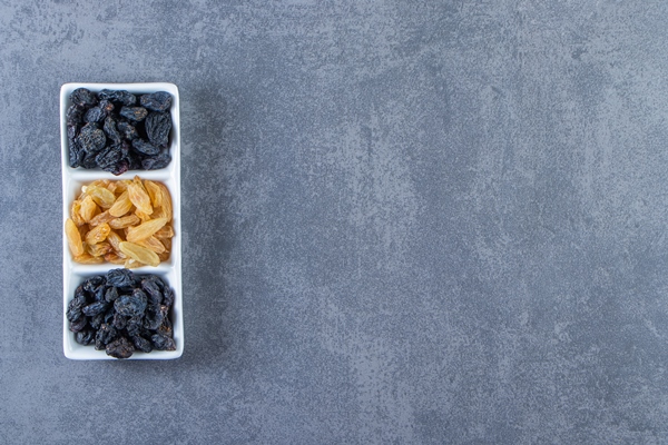 flavorful raisins on a dish on the marble background - Постный грибной суп с сухофруктами