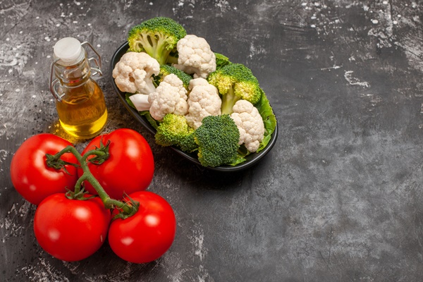 front view broccoli and cauliflower on plate tomatoes oil on dark background free space - Салат "Южный"