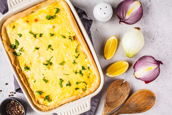 onion pie with cheese and herbs in black baking dish - Пирог с картофелем