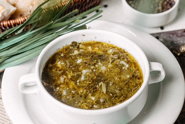 Суп из сныти с овсянкой side view of traditional russian green borsch with sorrel meat and eggs on a wooden board - Суп из сныти с овсянкой