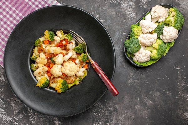 top view broccoli and cauliflower salad a fork in black bowl pink and white checkered napkin raw broccoli and cauliflower on plate on dark background free space - Салат "Южный"