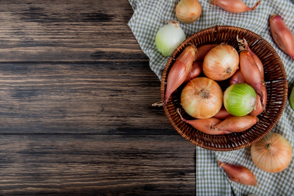 top view of onions as shallot sweet and white ones in basket on plaid cloth and wooden background with copy space - Свекольный салат