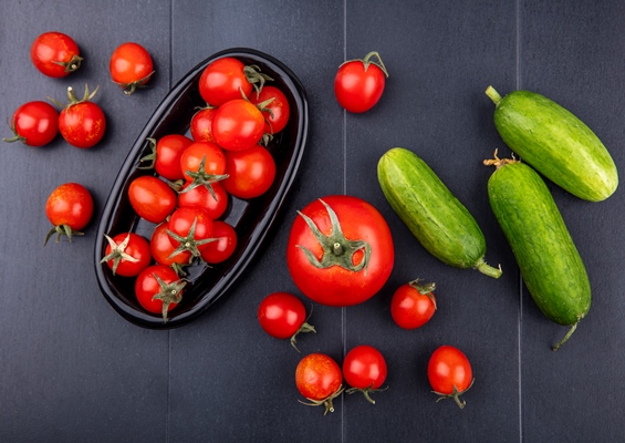 top view of tomatoes in plate with cucumbers on black surface - Кислый грибной суп, постный стол