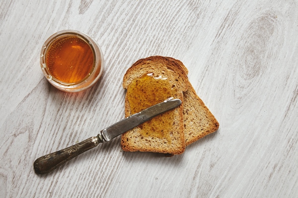 top view of two toast from organig rustic dry rye bread with artisan honey isolated on aged brushed - Коврижка из ржаного хлеба (без масла)