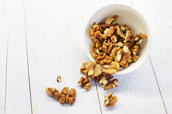 walnuts in the white bowl close peeled walnuts on a white colored old vintage wooden backdrop - Коврижка из ржаного хлеба (без масла)