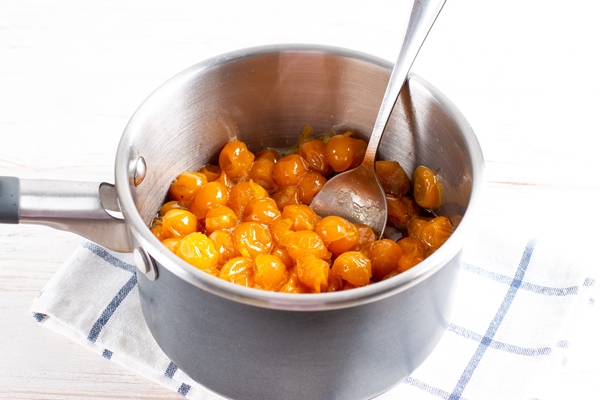 yellow cherry plum in a saucepan on a light table cherry plum for making tkemali sauce - Соус Ткемали