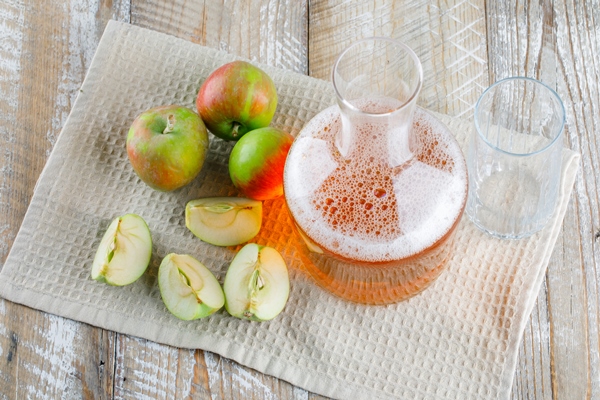 Квас из яблок apples with juice on wooden and kitchen towel - Квас из яблок