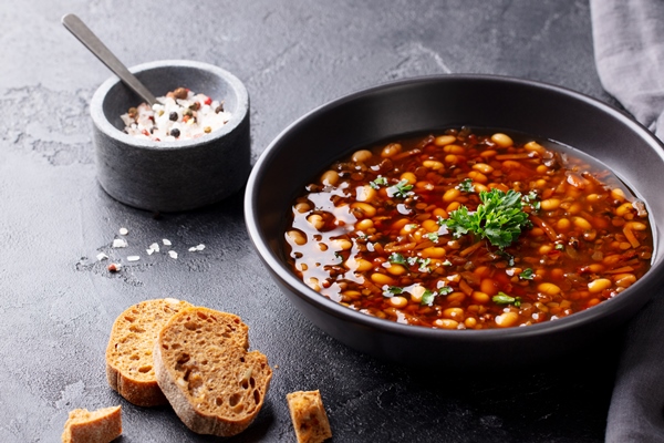 Постный суп с орехами bean soup in a black bowl black background copy space - Постный суп с орехами