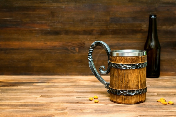 big brown mug of beerale bottle and crispy snacks pretzels corn nuts in bowl on wooden table background close up alcohol cocktail bar drink booze party conceptmockup template copy space - Кумал (квас по-осетински)