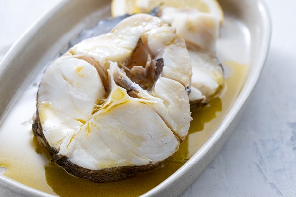 boiled fish with olive oil in dish on ceramic - Рассольник из рыбы