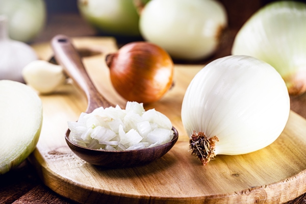 chopped onion and garlic in wooden spoon used in rustic kitchen setting seasoning ingredient - Суп острый из красной фасоли с орехами