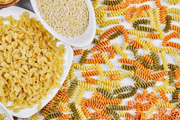 colorful fusilli and other raw pastas on white - Суп овощной с макаронами