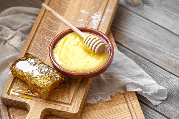 composition with natural honey and honey dipper on wooden background close up - Малиновый медовый квас