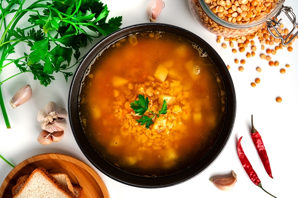 Суп из сушёного гороха pea soup on a white background pea soup in a black bowl parsley bread high quality photo - Суп из сушёного гороха