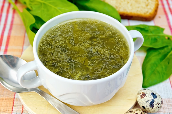 Суп из щавеля, крапивы и картофеля soup of green nettles sorrel spinach rhubarb leaves on a round wooden board - Суп из щавеля, крапивы и картофеля
