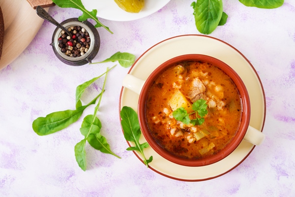 soup with pickled cucumbers and pearl barley rassolnik on a light table top view flat lay - Суп-рассольник с перловкой