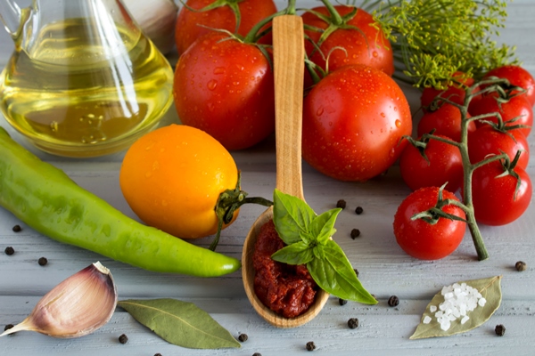 tomato paste in the spoon and vegetables on the grey wooden background - Суп овощной с макаронами