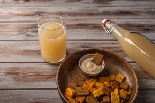 top view homemade traditional russian light rye kvass in bottle with glass cup and crackers on wooden 1 - Сорта квасов