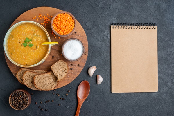 top view lentil soup with salt raw lentils and dark bread loaves on dark surface - Похлёбка чечевичная