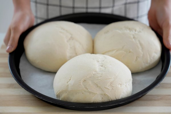 woman showing three homemade loaves of bread in baking tray ready to be baked 1 - Домашние городские булки