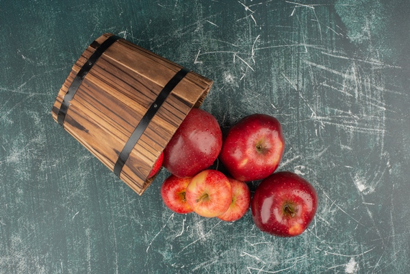 red apples falling out of bucket on marble table - Постная аджика острая