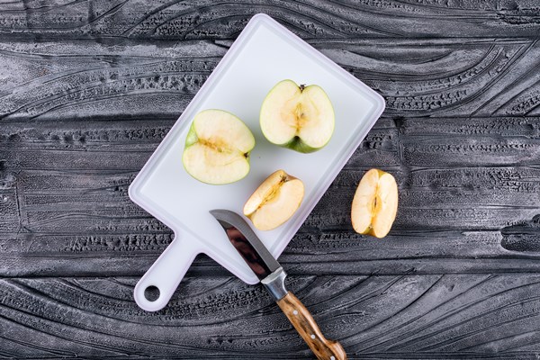 top view green apples sliced with knife on plastic board on gray wooden table and black 1 - Яблочная пастила с бананами