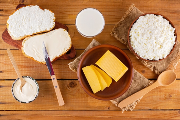 various dairy products bread with cream cheese on a wooden boards top view - Открытые бутерброды на завтрак