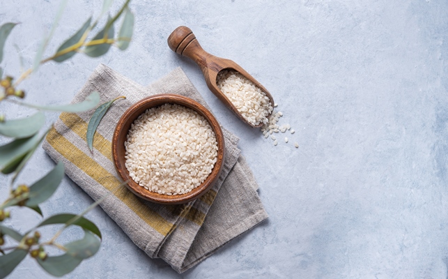 white rice arborio in a wooden bowl on a napkin - Салат с рисом и тунцом на Благовещение