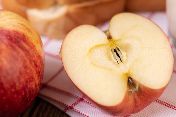 apple cut in half on a red white cloth placed on a wooden table - Капуста "провансаль"