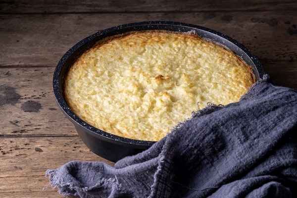 Рисовый постный пудинг с яблоками baking dish with tasty rice casserole on wooden background - Рисовый постный пудинг с яблоками