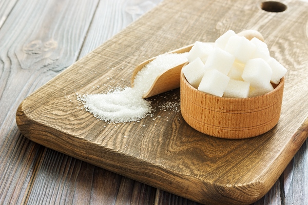 bowl and scoop with white sand and lump sugar on wooden background - Постное кокосовое печенье