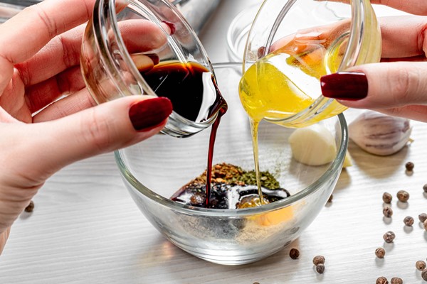 close up of female hands pouring honey and soy sauce into a bowl with spices - Основы сухоядения