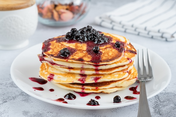 Овсяные постные оладьи delicious small pancakes drizzled with blueberry jam on a white plate - Овсяные постные оладьи