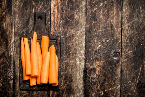 fresh peeled carrots on a cutting board on the old wooden table - Салат "Свежесть"