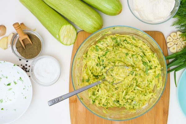 preparation of pancakes of zucchini and greens on a light background - Постные оладьи из кабачков